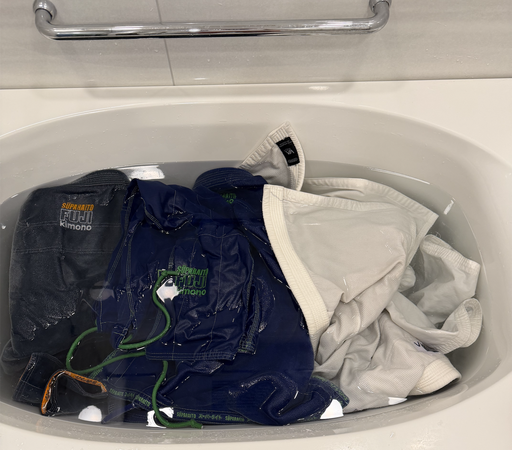 Two gis soaking in a bathtub for an overnight cleaning powder test